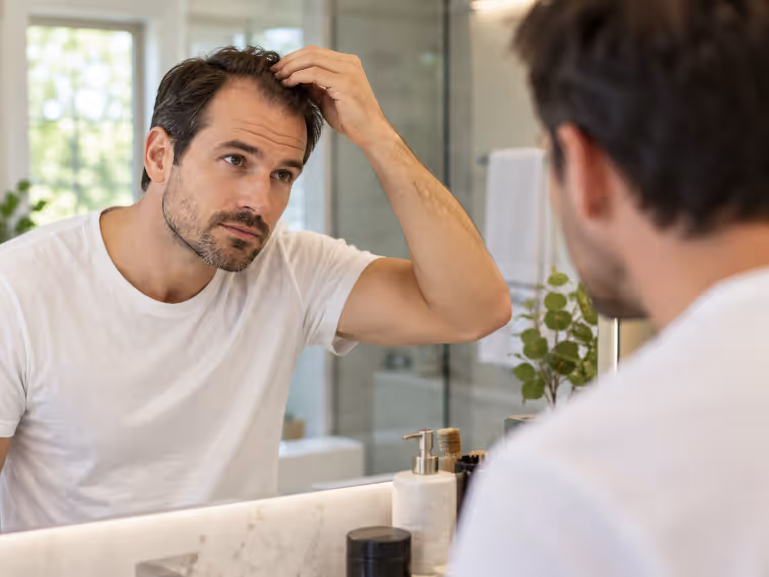 Man examining thinning hair and hair loss